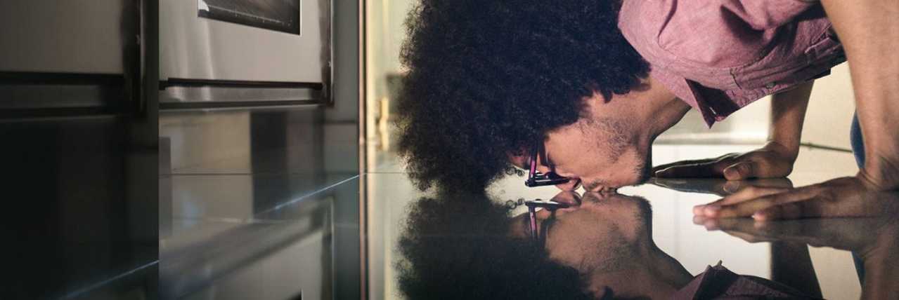 Hombre besando su reflejo sobre un piso brillante